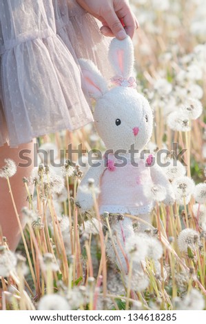 toy rabbit with dandelion in the park