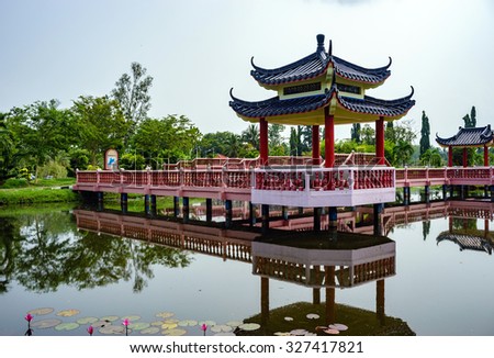 Beautiful garden with Chinese architectural bridge and reflection in the lake