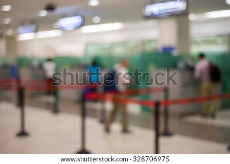 Blurred image of passengers at immigration checkpoint in airport terminal