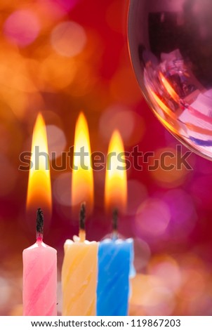 Three candle on the background of Christmas decorations