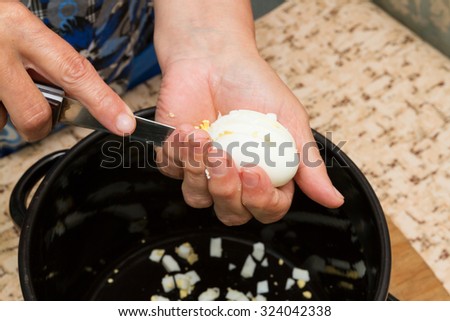 Cutting chicken eggs on your hand over the pan
