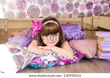 Girl in pretty dress lies on the floor