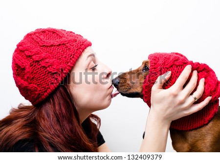 The girl with the dog, and both are in red hats