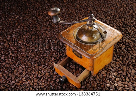 An old coffee grinder with a lot of coffee grain