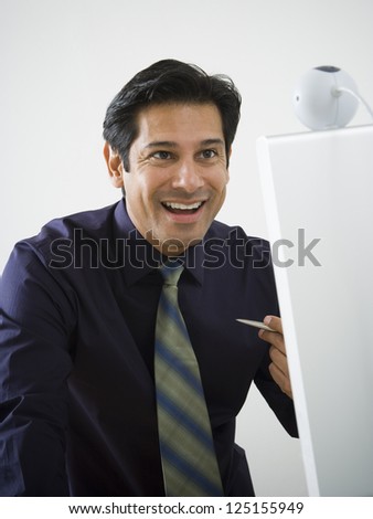 Hispanic business man smiling while using web cam