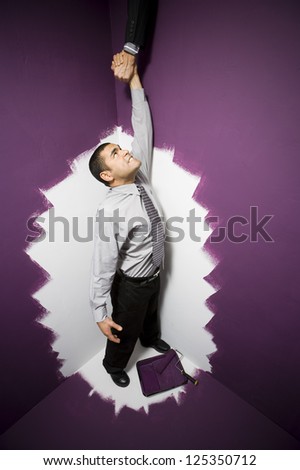 Business man captured by wall painting getting help to escape