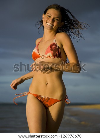Motion blur portrait of a teenage girl running on the beach