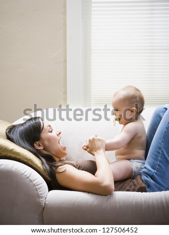 Woman lying down on sofa with baby