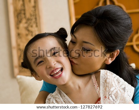Mother giving daughter a kiss on cheek