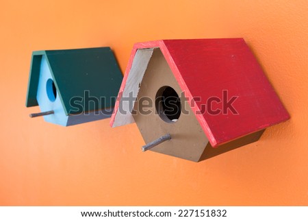 colorful bird nest wood box decorated on orange wall background