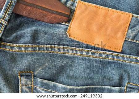 brown leather tag on blue jeans