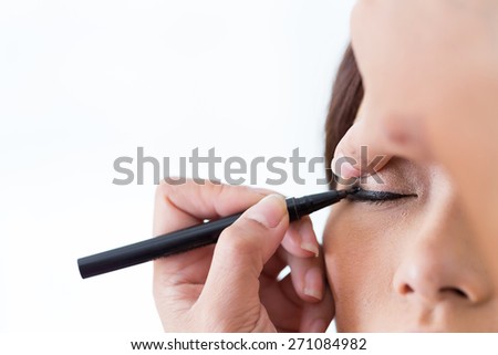 makeup beauty with brush eye liner on pretty woman face