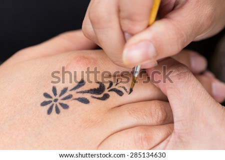 body paint, artist used paintbrush drawing art on hand person