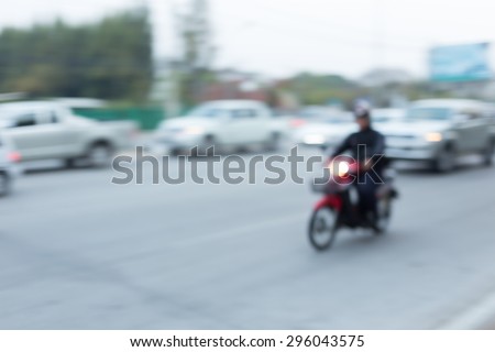 car and motorcycle driving on road with traffic jam in the city, abstract blurred background