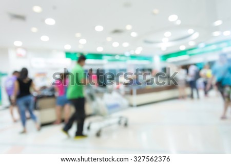people walking with shopping cart in department store shopping mall center, image blur defocused background