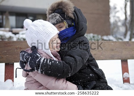 siblings hugging on a winter day