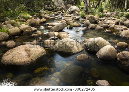 Rocks and flowing water in a creek bed at the base of the mountain Spicers Gap, Queensland, Australia.
