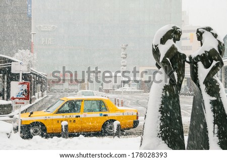 Yokohama, Japan - February 8, 2014: The taxi waits near a train station during snow storm in Yokohama, Japan