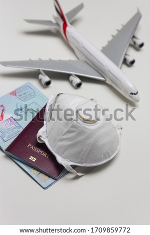 Travelling during corona virus epidemic. Passport and protective face mask respirator. Coronavirus and travel concept. Travelling with face mask. Corona virus prevention. Flights cancelled. Stay Home. Stock fotó © 