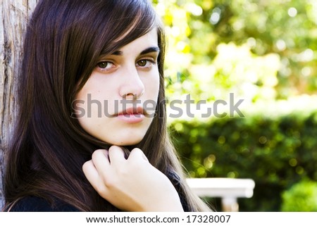Young staring woman with green nature color as background