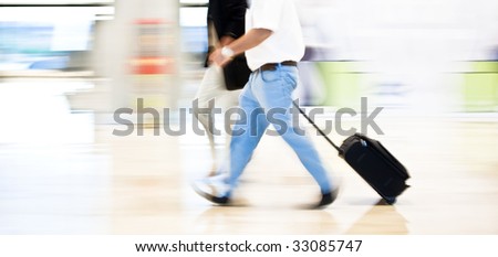 Two business men moving quickly on the terminal. Panning technique.