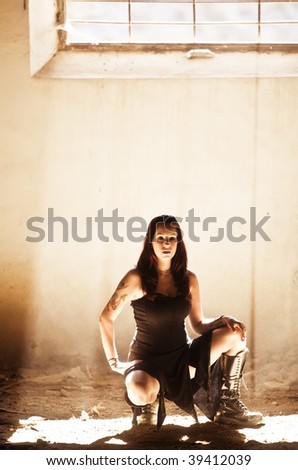 Gothic young girl under raylight coming from window