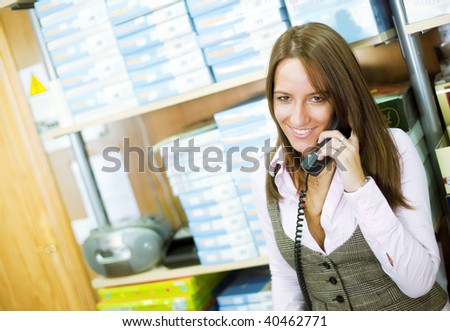 Shop assistant doing business at phone