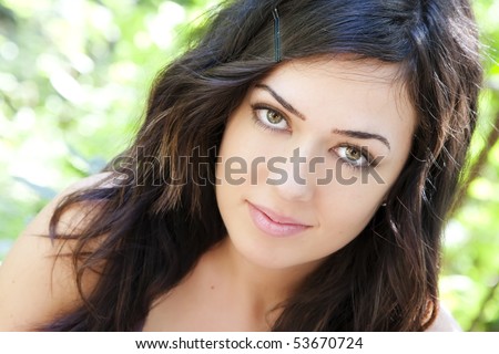 Beautiful woman with impressive green eyes staring at camera.