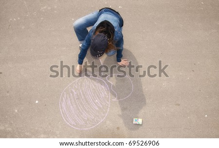 Young artist painting on the street