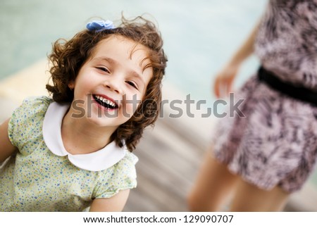 Little child portrait, with her smiling mother in a second term