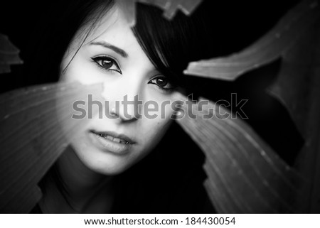 Woman looking through dirty broken glass