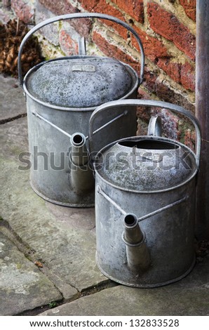 A pair of galvanized metal watering cans