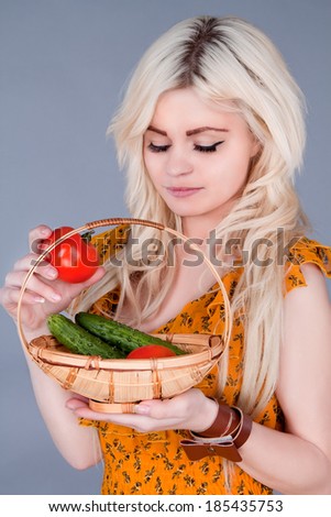 blonde girl lays down a basket of tomatoes and looking down