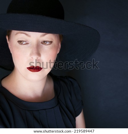 Redhead woman in old navy blue. Red lips. Vintage mood.