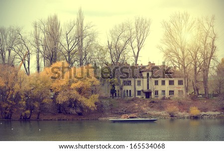 Beautiful autumn scene with old hotel and lake
