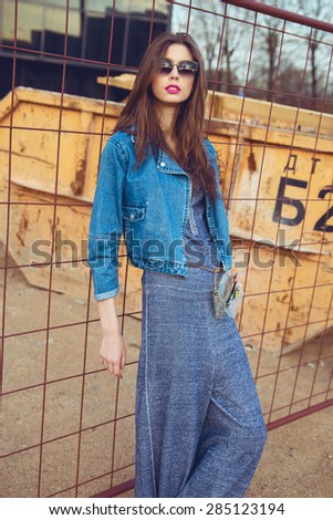 Fashion model hipster in jeans clothes and sunglasses