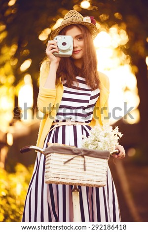 hipster photographer beautiful, elegantly dressed woman with bicycle. Beauty, fashion and lifestyle