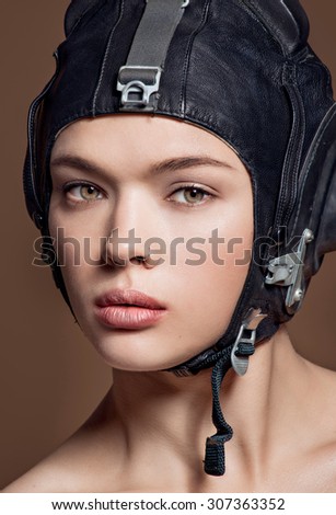 Woman in black helmet and professional makeup close up portrait on dark backgground