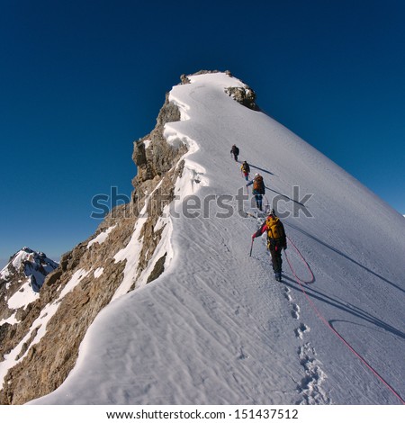 Tied climbers climbing mountain with snow field tied with a rope with ice axes and helmets ストックフォト © 