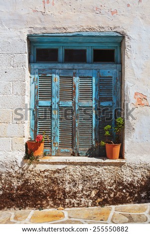 Rustic blue window and flower pots in Halki village, Naxos Island, Greece.