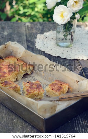 Eating outdoor - homemade lemon pie in baking pan on rusted garden table