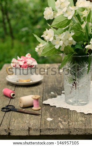 Still life with jasmine bouquet in crystal vase on rusted wooden table