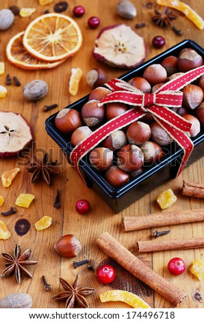 Decoration - hazelnut in baking pan and mixed spices and dried fruits on wooden table
