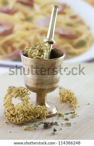 Mortar with dry herbs on the table. Focus on the front. Food background.