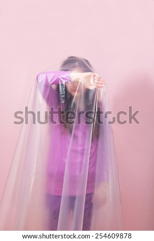 Unhappy Young Girl in Plastic Foil. Concept: Domestic and Family Violence. Abuse Child.