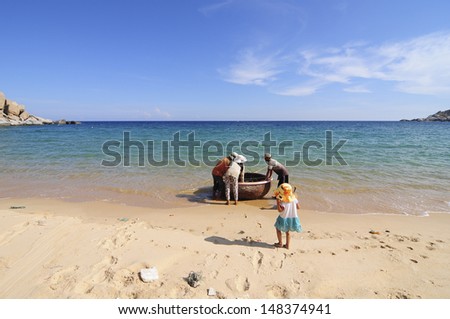 NINHTHUAN, VIETNAM, MAY 2: Unidentified family pull their boat on the beach after fishing trip on May 2, 2013 in Ninhthuan, Vietnam. This family lives in a deserted beach in Ninh Thuan