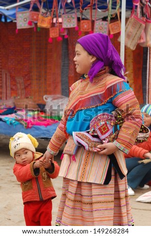 LAOCAI, VIETNAM, FEBRUARY 10: Unidentified ethnic minority woman with her son  in a traditional market on February 10, 2012 in Bac ha, Vietnam. There are many ethnic minority groups in Bacha