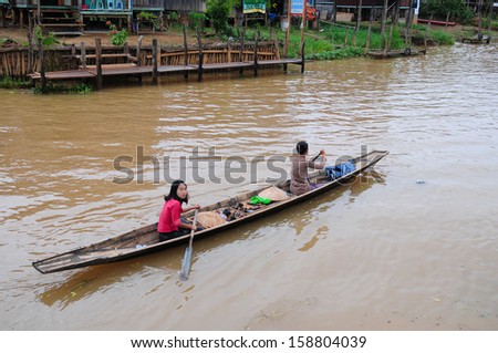 INLE LAKE, MYANMAR - SEPTEMBER 6 :Two unidentified people on a boat to market on September 6, 2013 in Inle Lake, Myanmar. They live in a village on lake.