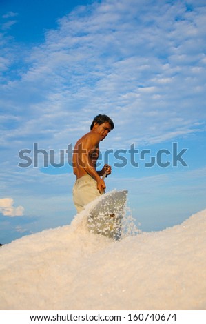 NINHTHUAN, VIETNAM, MAY 03: Unidentified man works in salt field on May 03, 2013 in Ninhthuan, Vietnam. Ninhthuan is central province in Vietnam