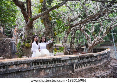 HUE, VIETNAM, MAY 3: Vietnamese girls with Ao Dai in Tu Duc royal tomb on May 3, 2014 in Hue, Vietnam. Ao dai is famous traditional costume for woman in VIetnam.